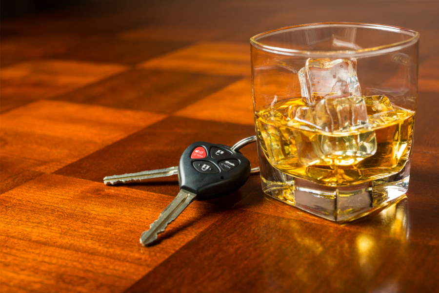 car keys beside glass of alcohol